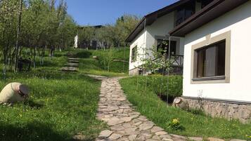 Stroll along the garden path to a serene retreat with a large window and lush surroundings.