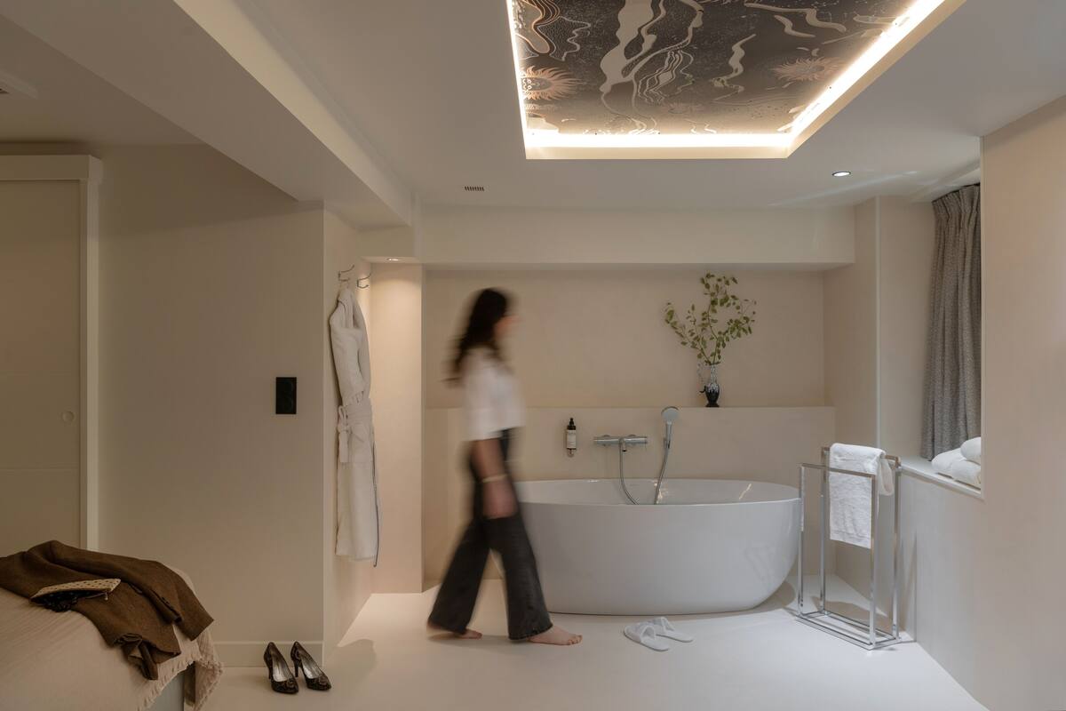 A modern bathroom with a freestanding bathtub, a towel rack, and a visible shower area.
