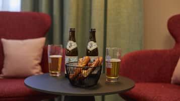 Ein Tisch mit zwei Bierflaschen, einem Bierglas und einer Brezelkorb.