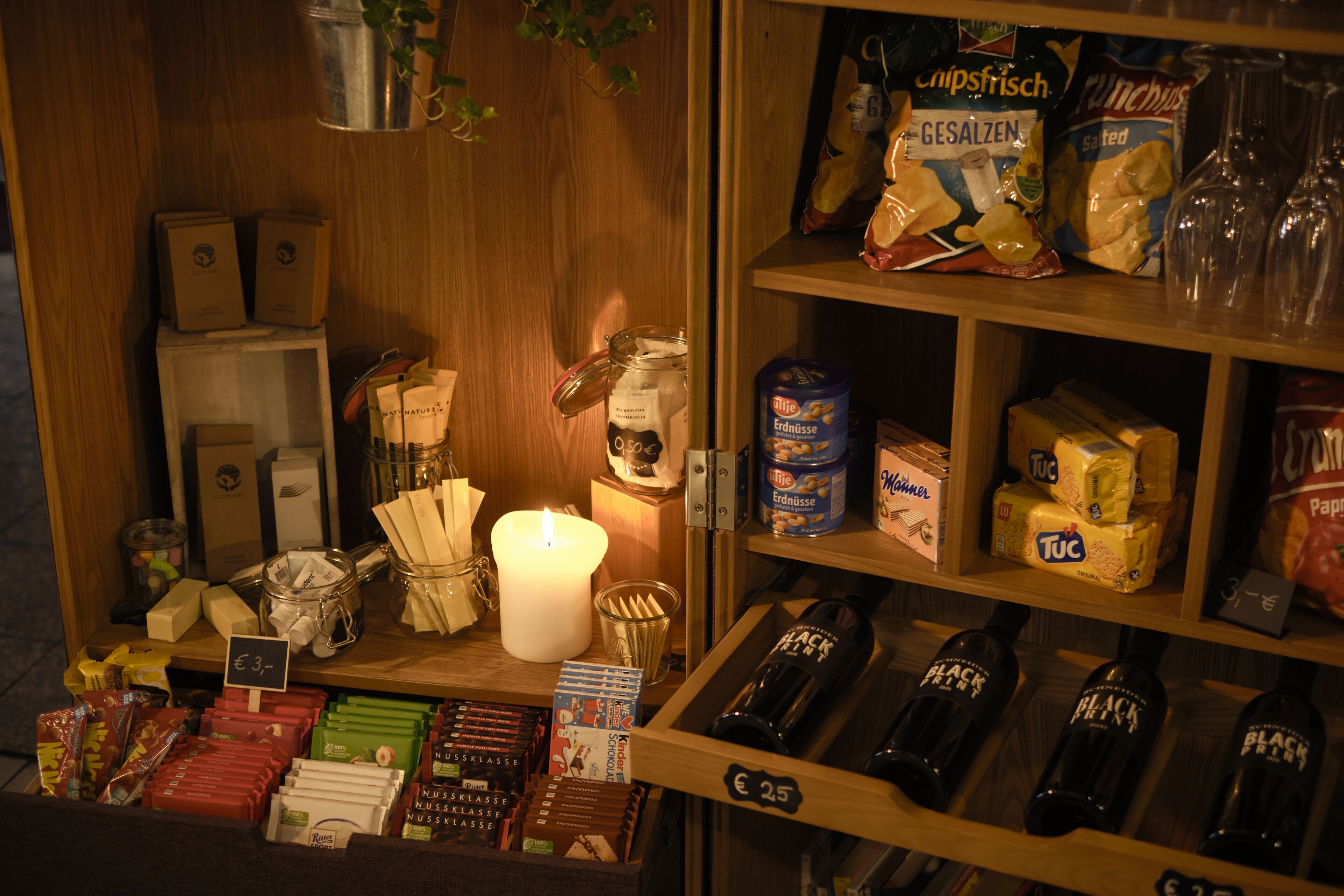 A shelf stocked with snacks, condiments, and bottled beverages.