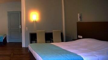 Une chambre d’hôtel avec un lit, un bureau et une chaise.