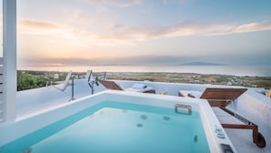 A rooftop pool with a view of the sea and distant land. - Fava Eco Suites (Santorini)
