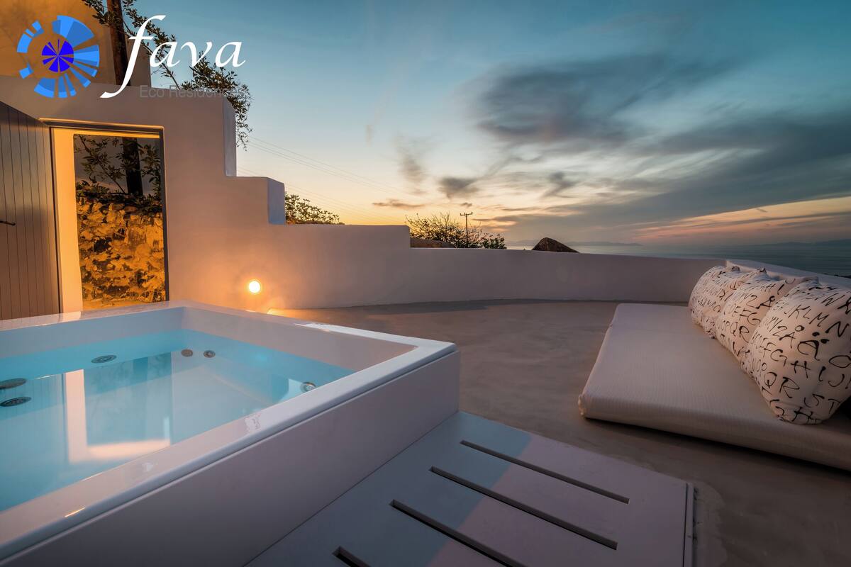A modern outdoor relaxation area with a hot tub, white lounge chairs, and a view of the sunset.