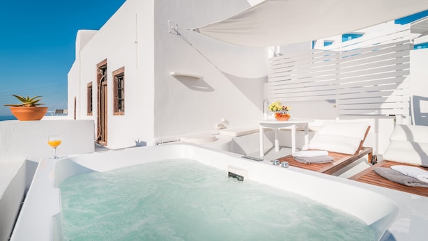 A rooftop infinity pool with a hot tub, white furniture, and a potted plant. - Fava Eco Suites (Santorini)