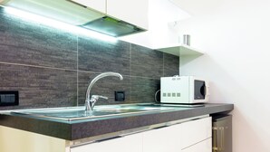 A modern kitchen with a stainless steel sink, a microwave, and a built-in oven. - Suiteincenter Apartments (Palermo)