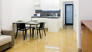 A compact kitchen with a dining area, a microwave, and a sink. - Suiteincenter Apartments (Palermo)