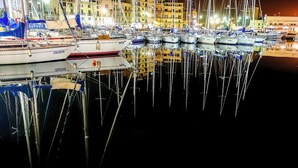 A marina with multiple boats docked, reflecting in the water. - Suiteincenter Apartments (Palermo)