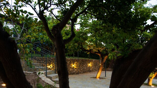 Un patio empedrado con pared de piedra y escalera de metal.
