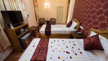 A hotel room with two beds, a TV, a desk, and a chair.