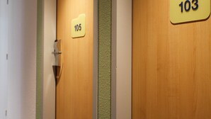Een hotelgangen met houten deuren, elk voorzien van een nummer.