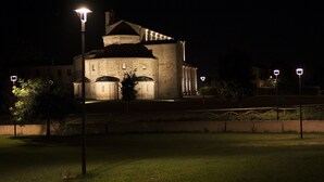 A historic building with a prominent tower and dome, illuminated by street lamps. - Hotel La Luma (Montecosaro)