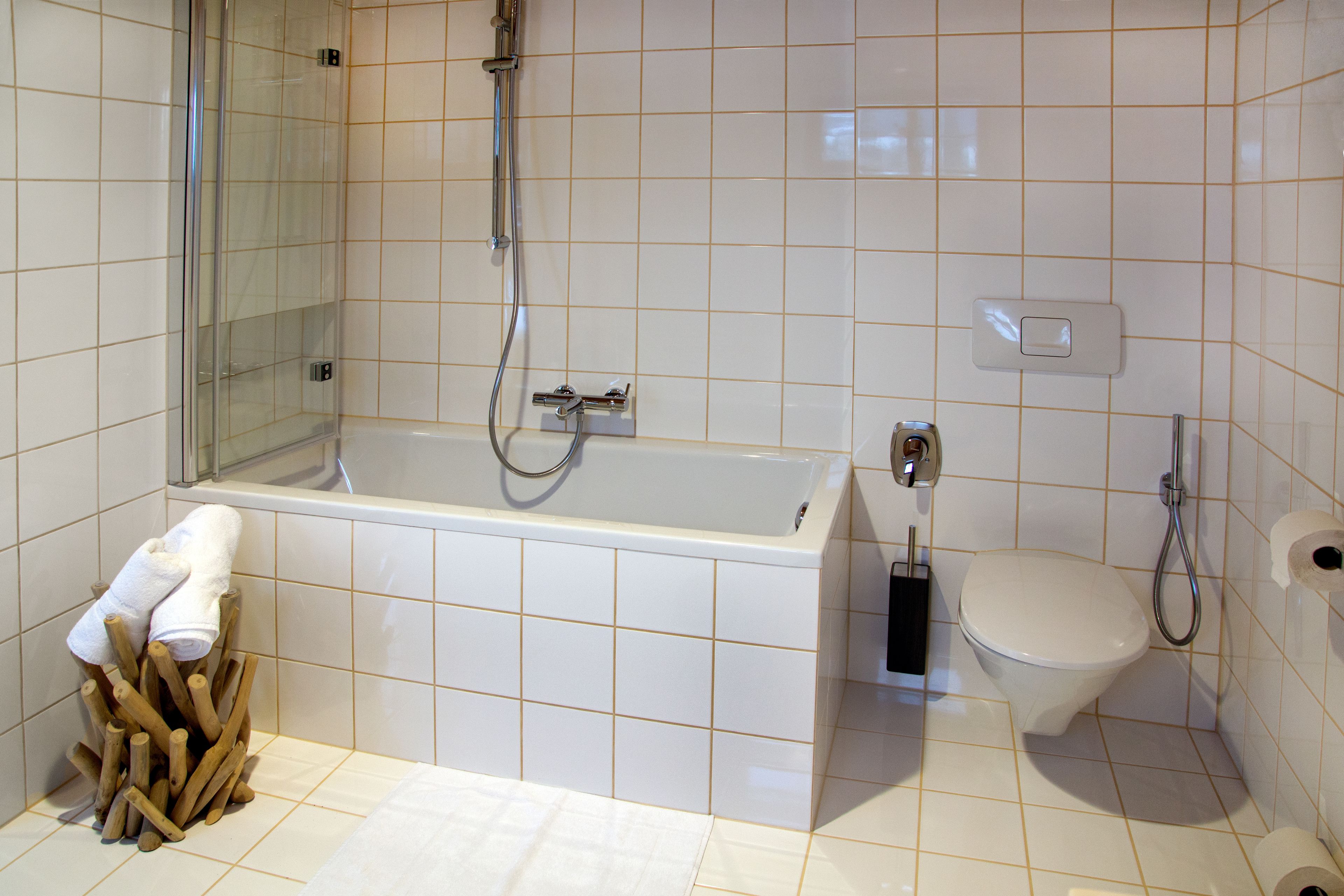 Een badkamer met bad, toilet en douche.