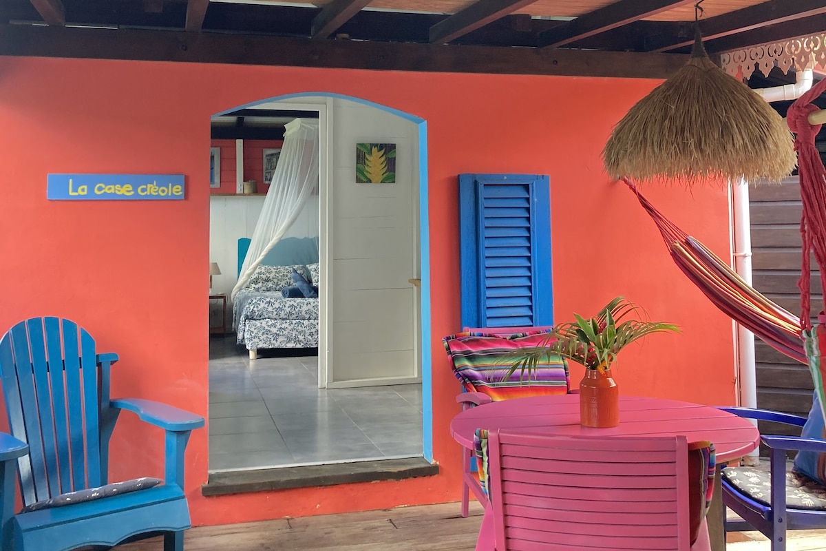 Una habitación con cama, una silla, una mesa y una hamaca.
