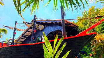 A boat with a red stripe, a steering wheel, and a flag.