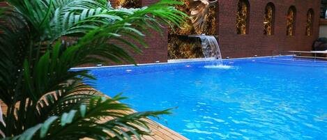 Una piscina al aire libre de temporada, sombrillas