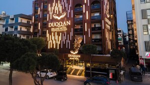 A multi-story hotel with a prominent sign reading "DUQQAN DELUXE HOTEL". - Duqqan Deluxe Hotel (Kusadasi)