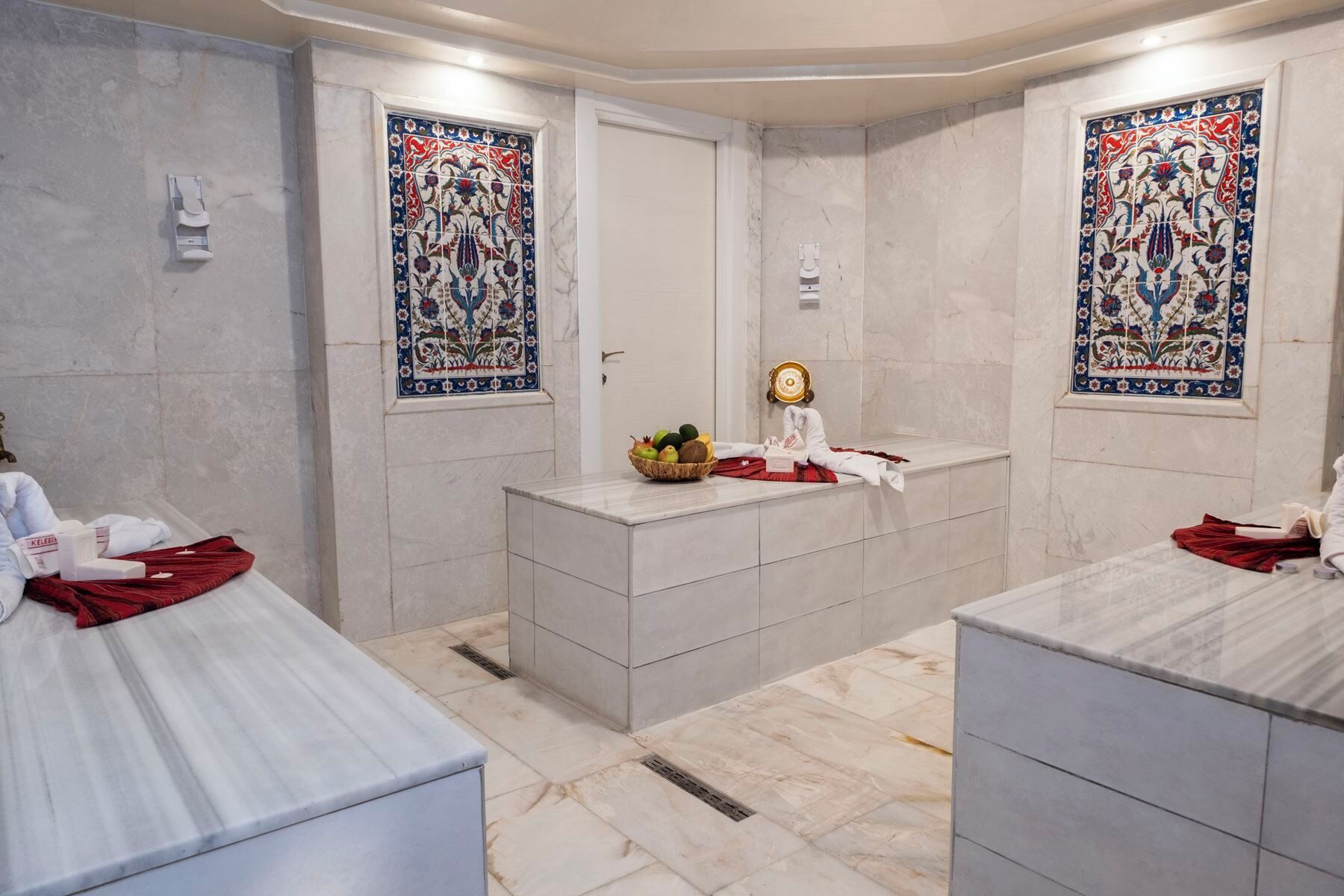 A bathroom with two sinks, a mirror, and a decorative tile wall.