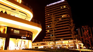 A modern hotel with a curved facade and multiple floors. - Platform Merter Suites (Istanbul)