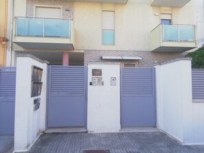 A gated entrance with a metal gate, a small window, and a wall-mounted intercom. - B&B Li Figuli (Lecce)