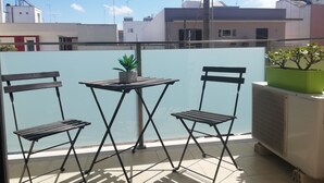 A balcony with two chairs, a small table, and potted plants. - B&B Li Figuli (Lecce)