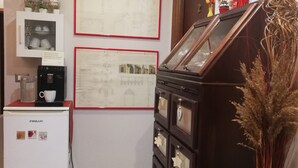 A kitchen with a white refrigerator, a coffee machine, and a cabinet with decorative items. - B&B Li Figuli (Lecce)