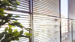 A corridor with metal blinds and a potted plant. - Bonavista Apartments - Virreina (Barcelona)