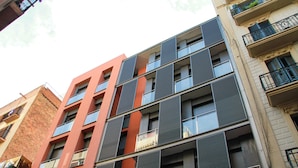 A multi-story building with a modern architectural design, featuring balconies and large windows. - Bonavista Apartments - Virreina (Barcelona)