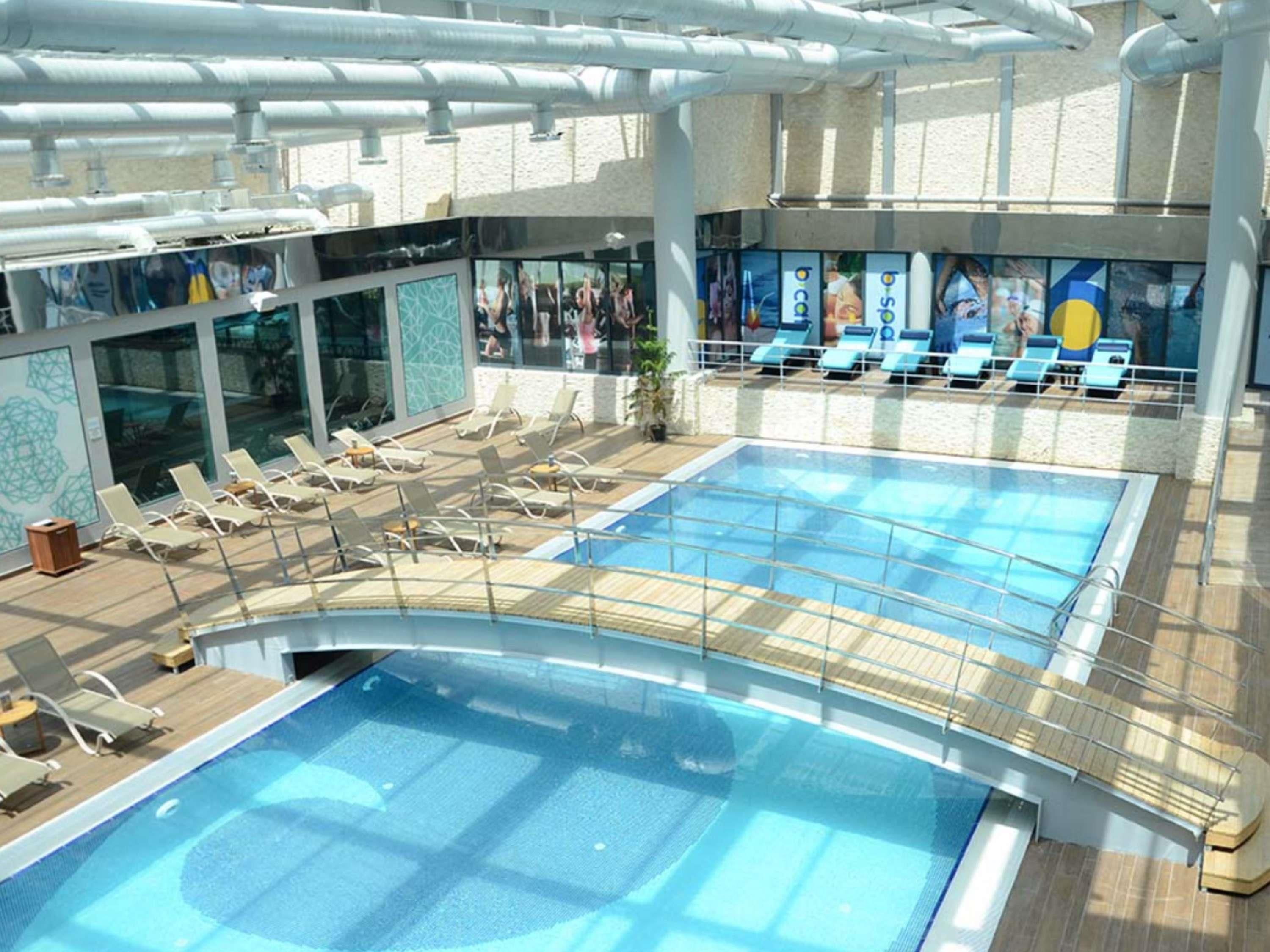 A pool area with sun loungers and a glass-enclosed deck.