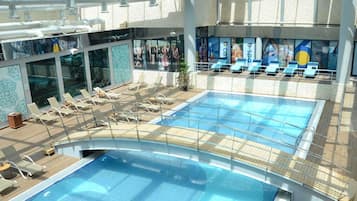 Zona de piscina amb gandules i terrassa tancada amb vidre.