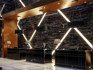 A modern reception desk with a marble wall and geometric lighting accents. - Pullman Istanbul Airport and Convention Center Hotel (Istanbul)