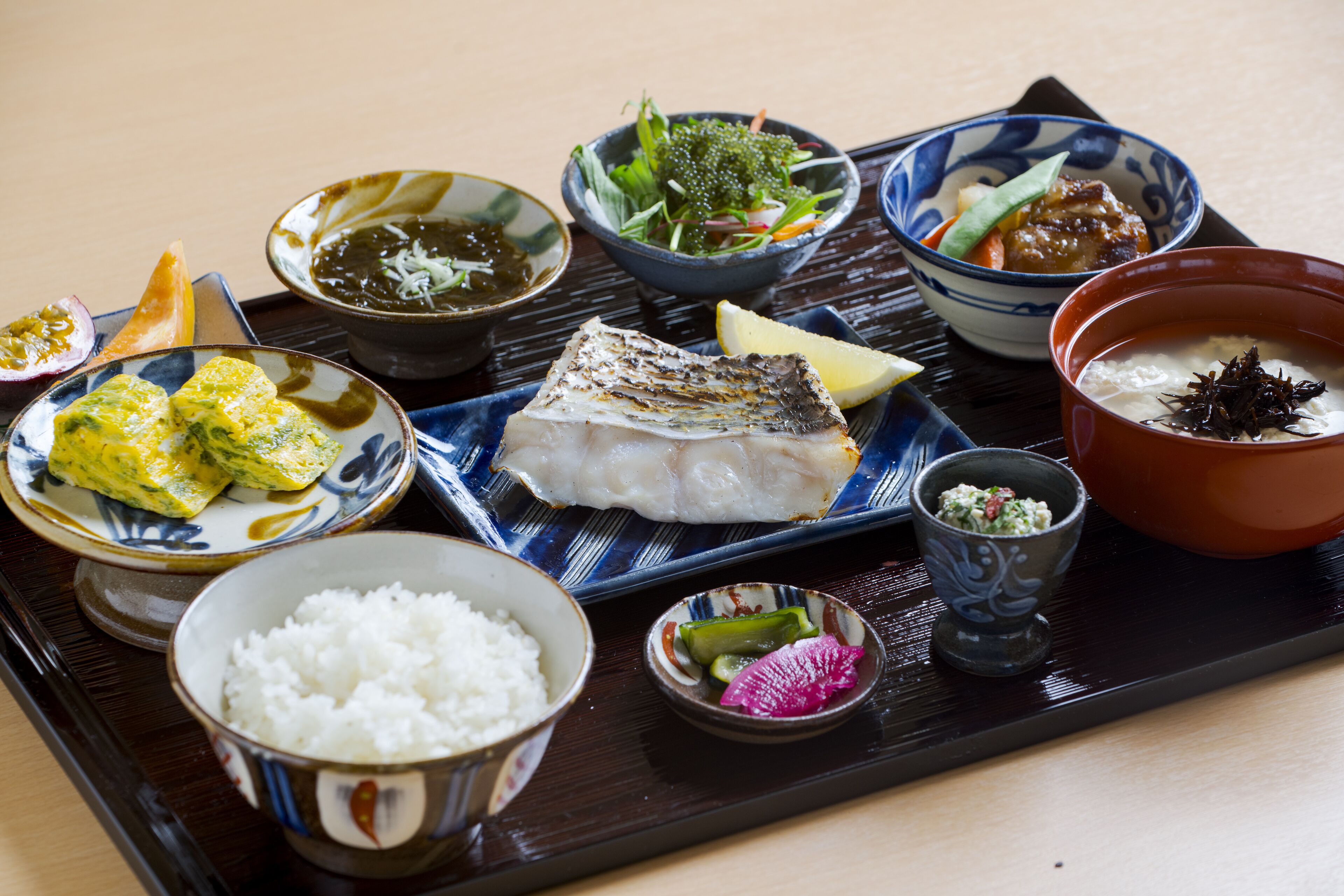 Eine traditionelle japanische Mahlzeit mit verschiedenen Gerichten, darunter Reis, Fisch und Gemüse.