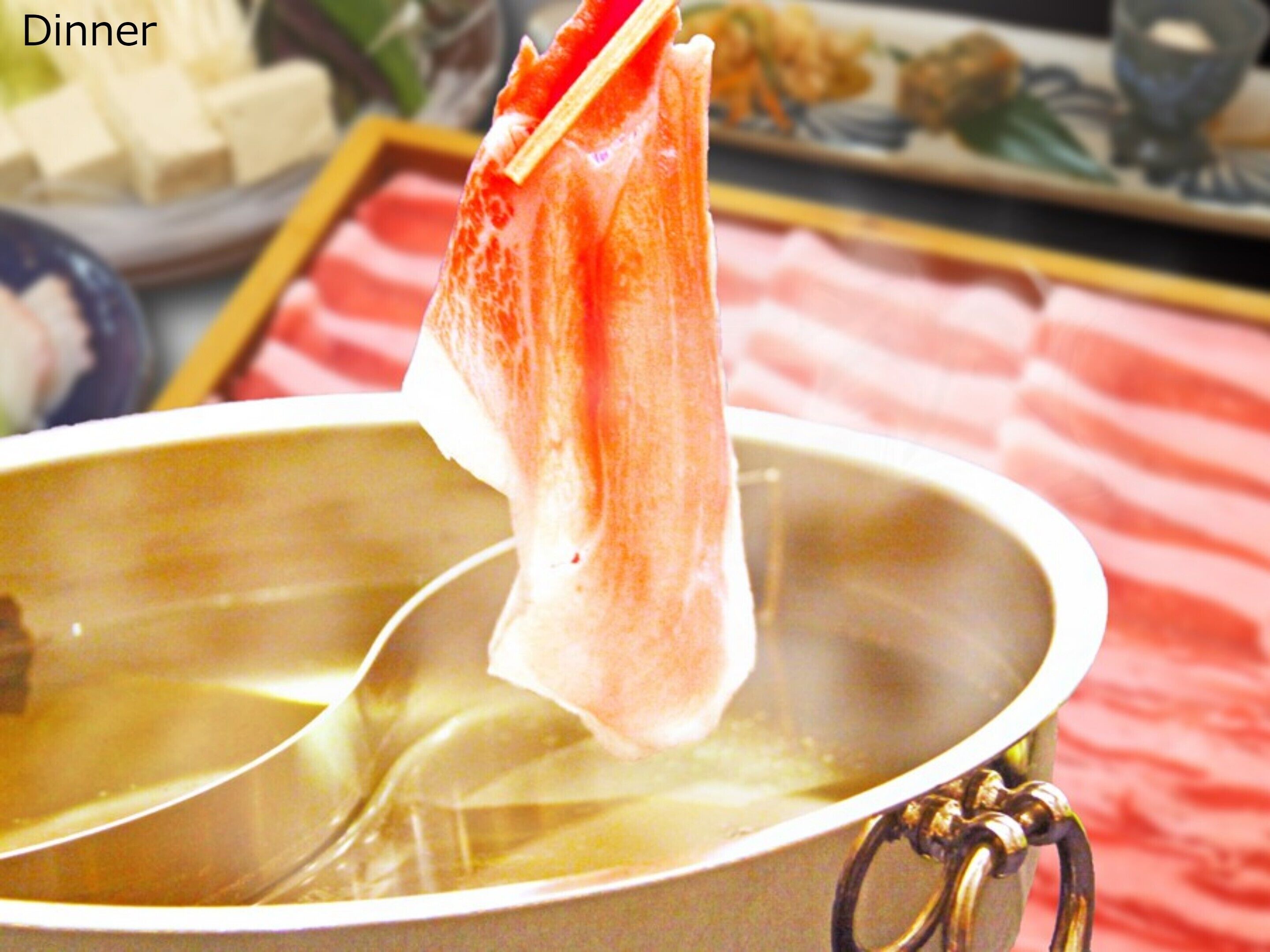 A pot with a handle, containing a clear liquid, possibly soup or broth, with a piece of food floating in it.