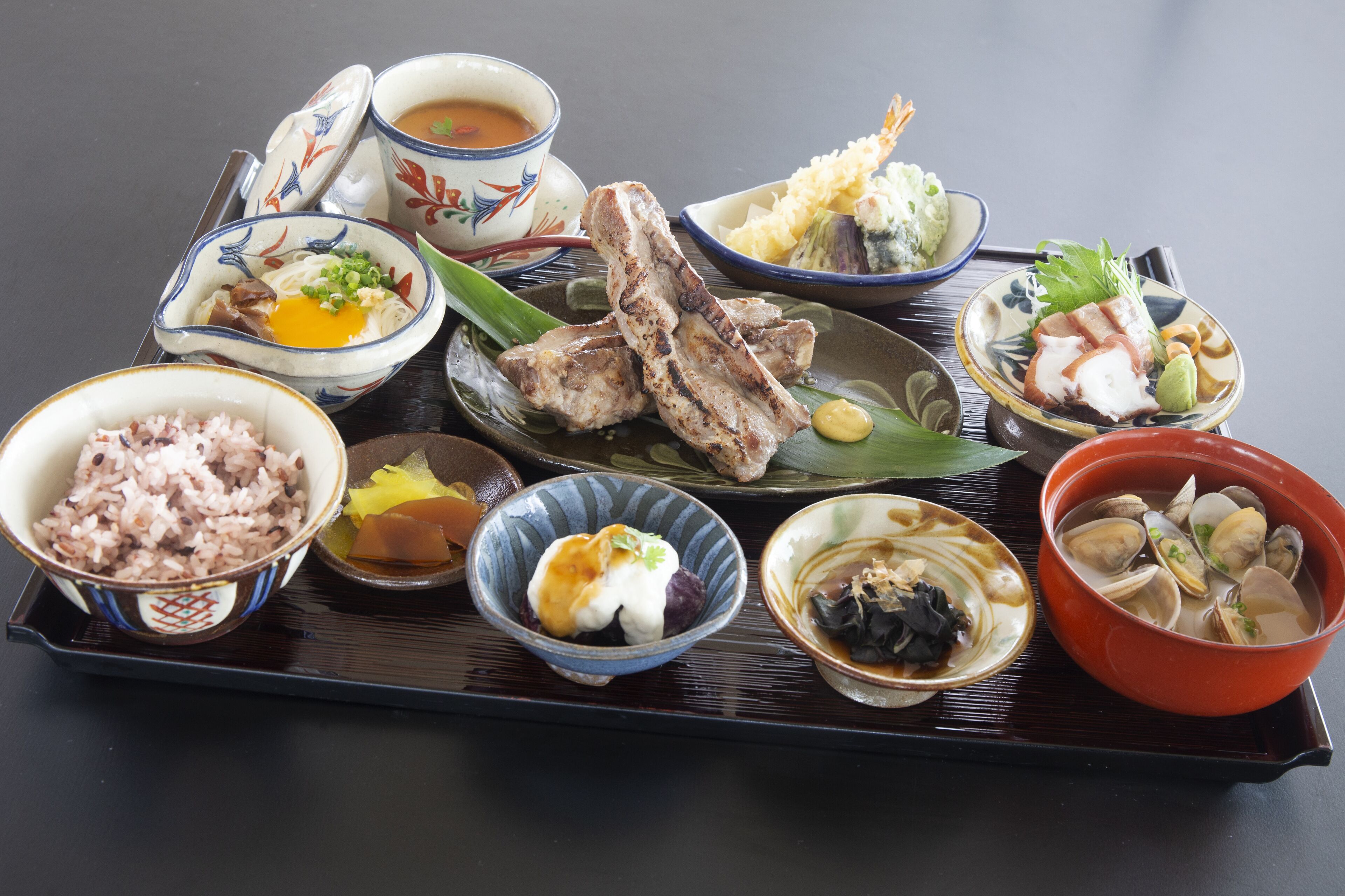 A tray with various dishes including rice, soup, and seafood.