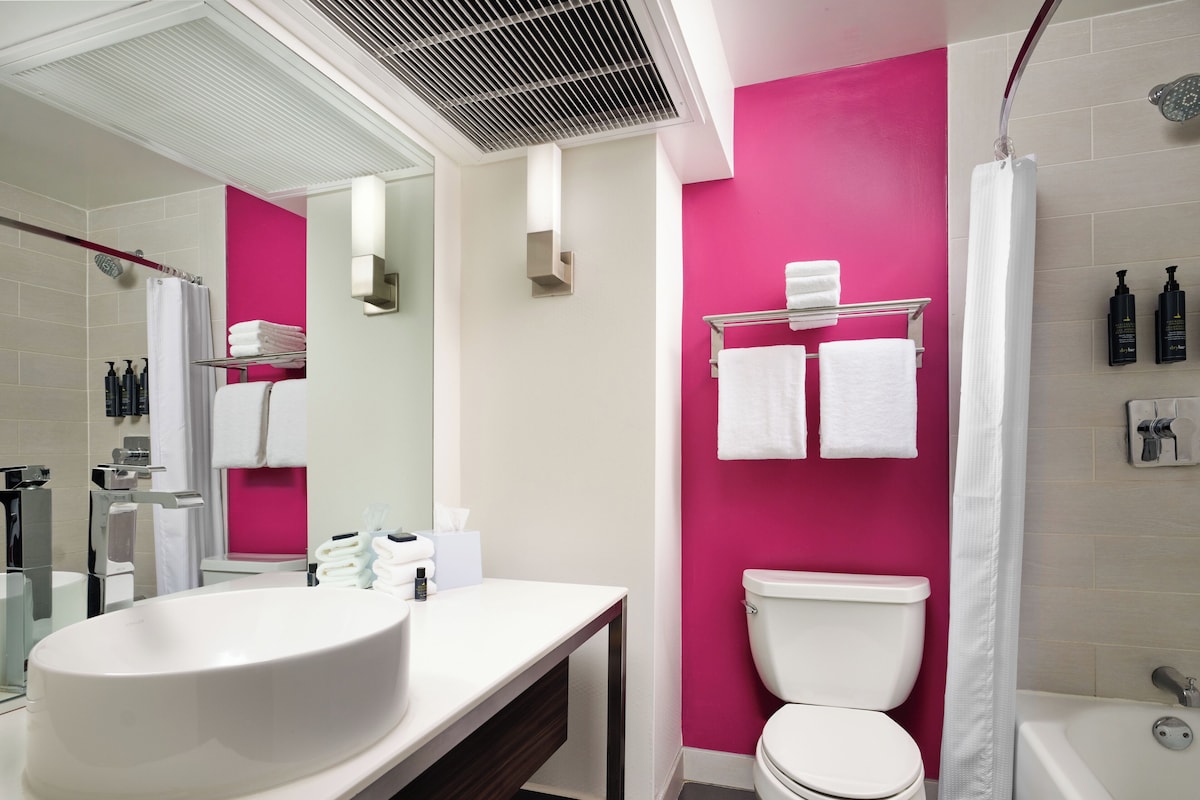 A modern bathroom with a white sink, a toilet, and a bathtub.