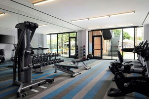 A gym with treadmills, dumbbells, and weight machines.