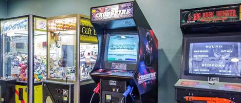 A row of arcade machines including 'Time to Win', 'Gift Box', 'Crossfire', and 'Big Buck Hunter'.