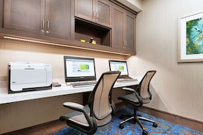 A workspace with two desks, each with a computer and a printer. There are two office chairs and a carpeted floor. - Hilton Garden Inn Lenox Pittsfield (Pittsfield)