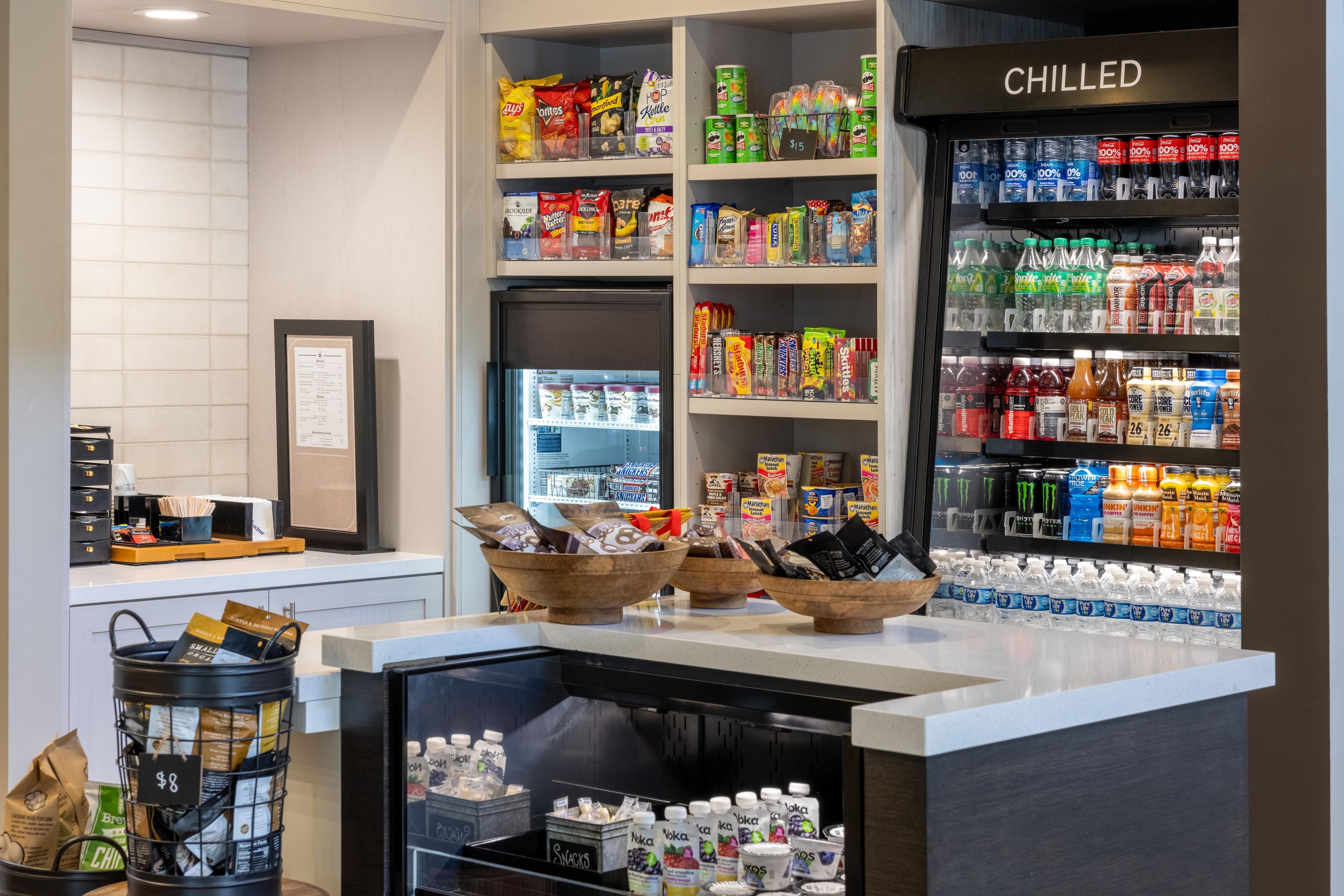 A snack bar with a variety of packaged snacks, a chilled beverage section, and a coffee station.