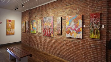 An art gallery with a brick wall and wooden floor.
