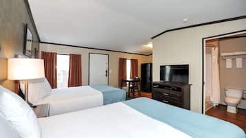 Una habitación de hotel con dos camas, un escritorio, televisión y baño.