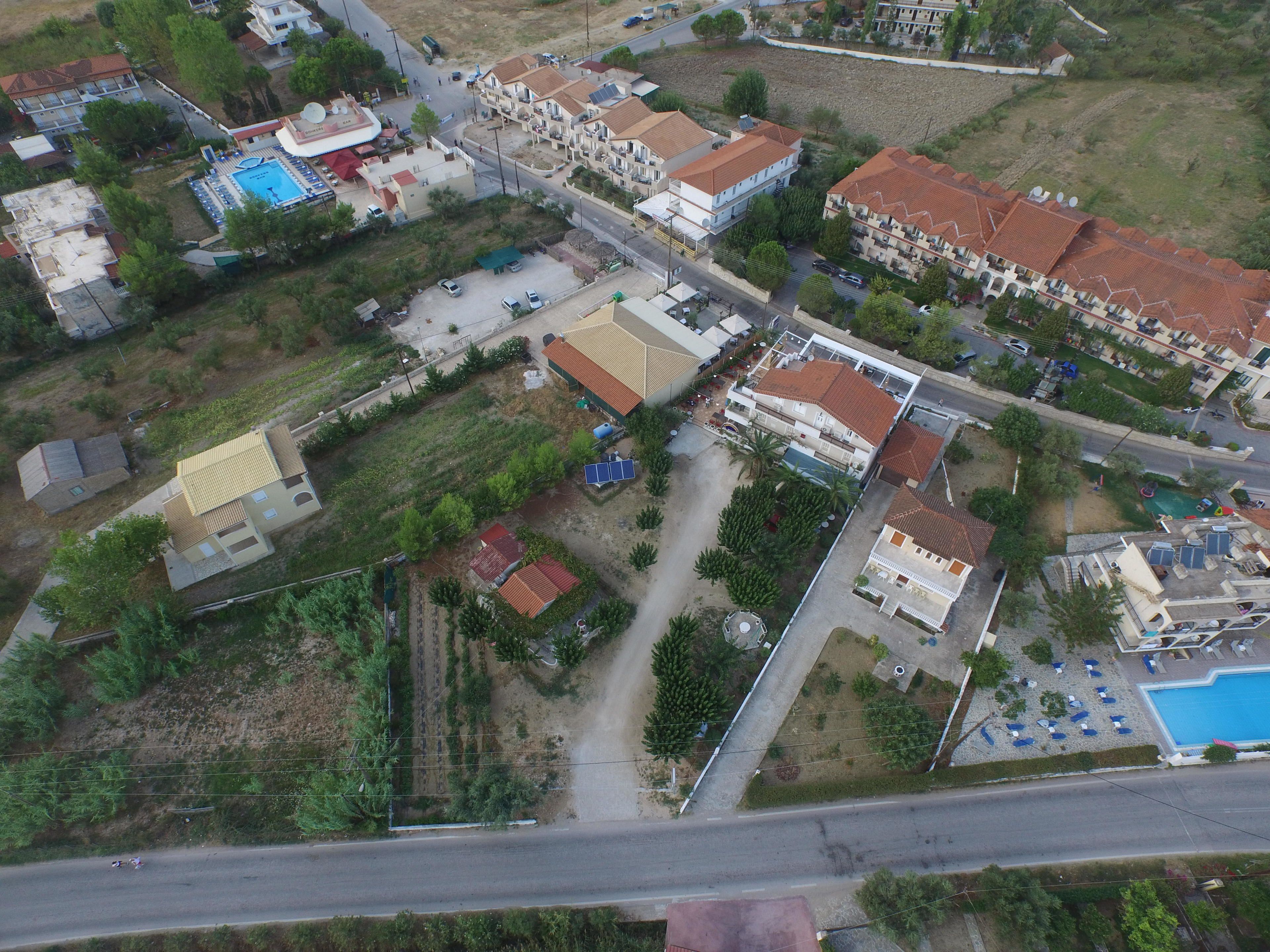 An aerial view of a residential area with multiple buildings, roads, and a swimming pool.