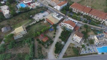 An aerial view of a residential area with multiple buildings, roads, and a swimming pool.