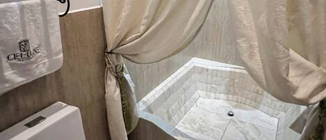 A bathroom with a bathtub, toilet, and towel rack.