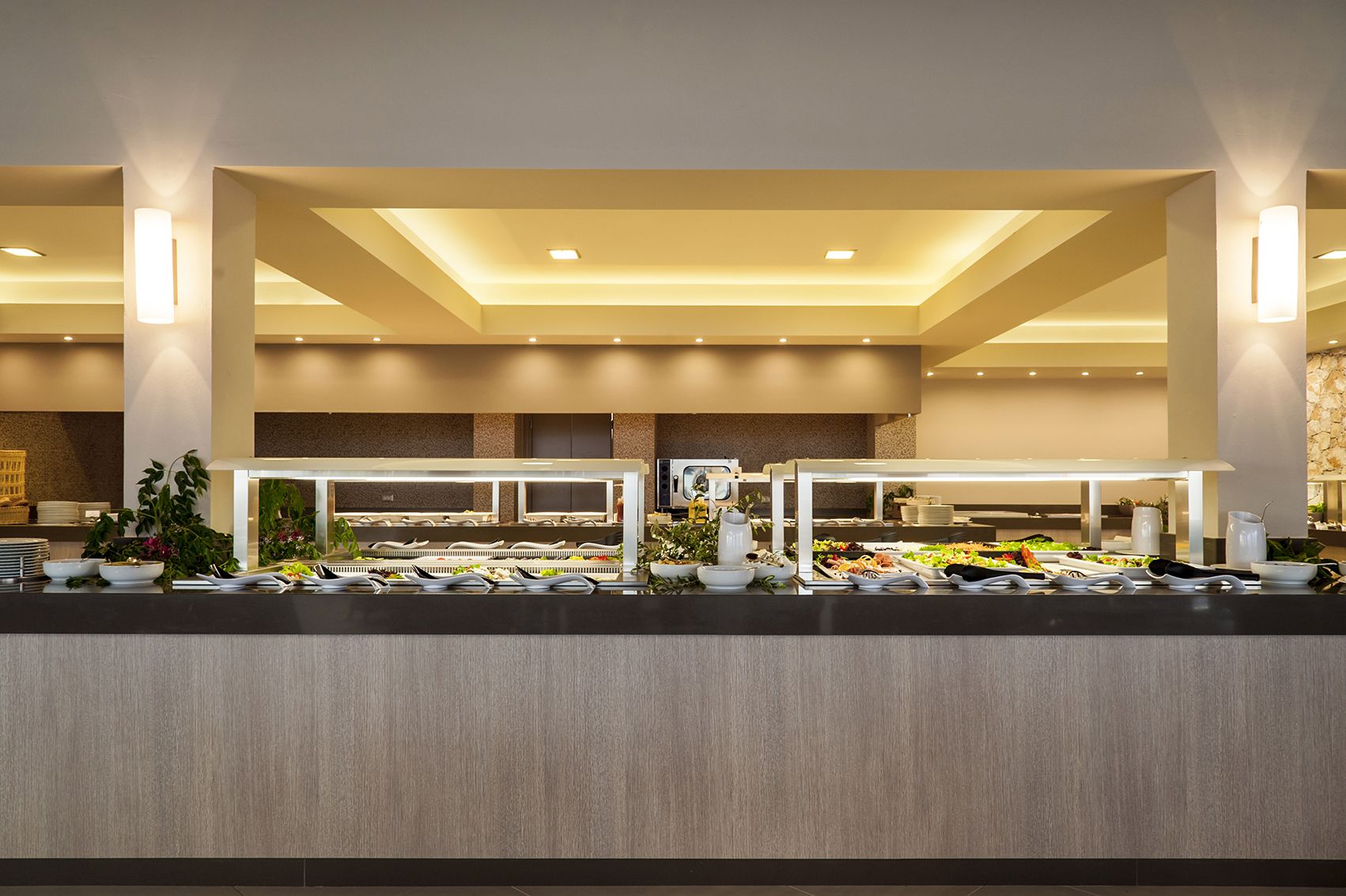 Un buffet proposant une variété de plats, avec plusieurs stations de service et un décor intérieur moderne.