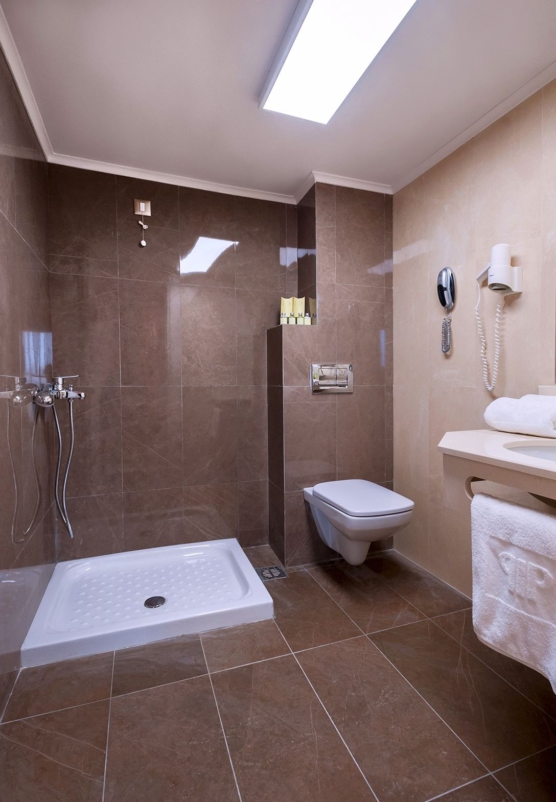 A modern bathroom with a shower, toilet, and sink.