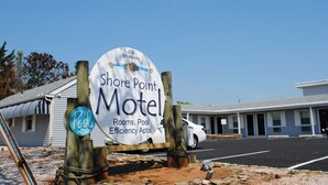 A motel sign with the name 'Shore Point Motel' and mentions rooms, pool, and efficiency apartments.