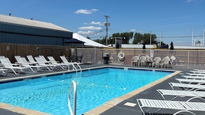 A swimming pool with lounge chairs and a fenced area.