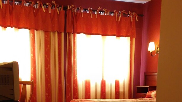 A hotel room with a bed, a desk, a chair, and a television. - Hotel Puerta De Javalambre (La Puebla de Valverde)