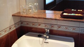 A bathroom with a white sink, a mirror above it, and a towel rack with towels. - Hotel Puerta De Javalambre (La Puebla de Valverde)