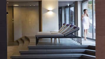 Un área de spa moderna con sillones reclinables y una pared de vidrio.